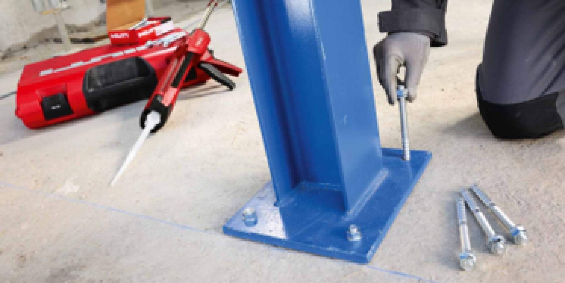 Worker installing mechanical anchors in baseplate.