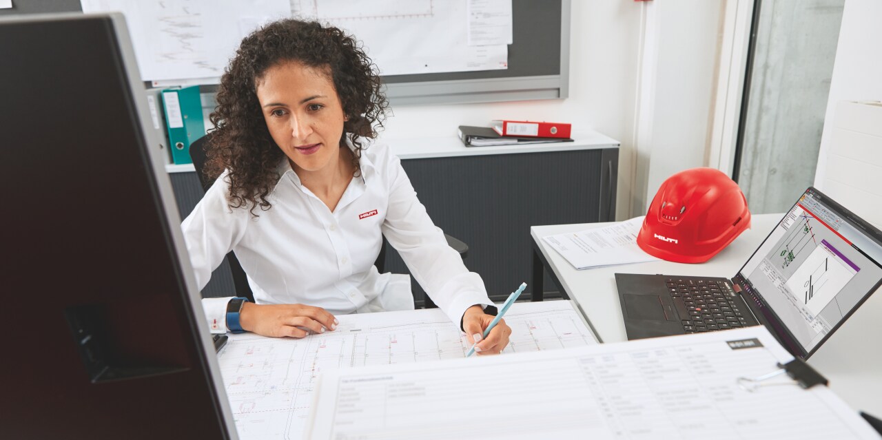 Hilti engineer onsite with a customer with shop drawings in the foreground