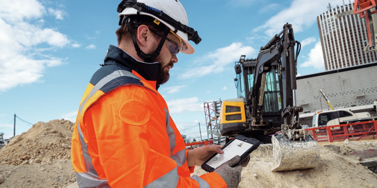 Crew member checking heavy equipment status on their ON!Track mobile app