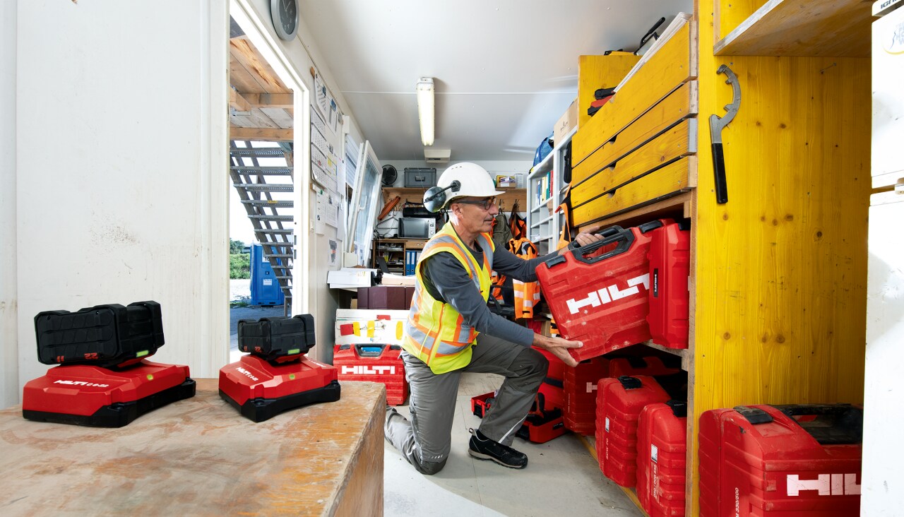 Tool Crib Manager putting away a Hilti Tool Box on a shelf in a construction container