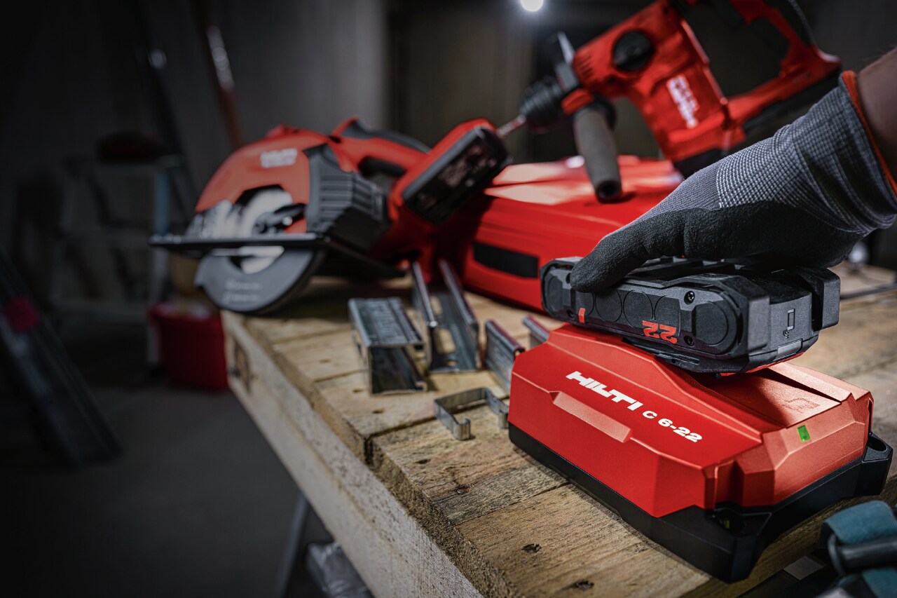 person putting a battery onto a hilti charger