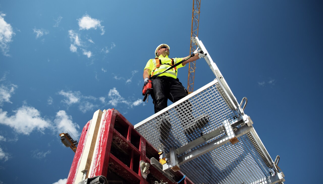 man standing on the jobsote ladder on a sunny day