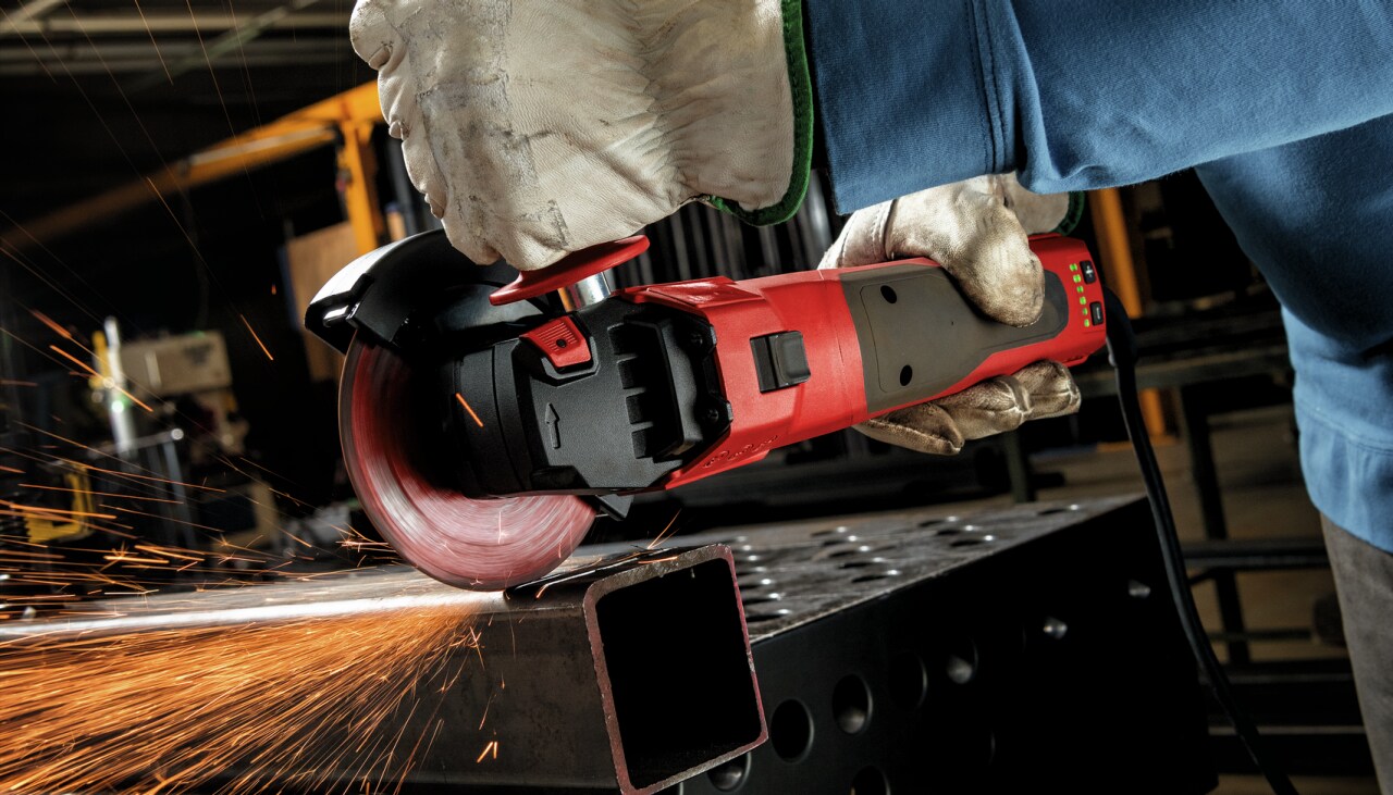 A man cutting metal channel with Angle grinder.