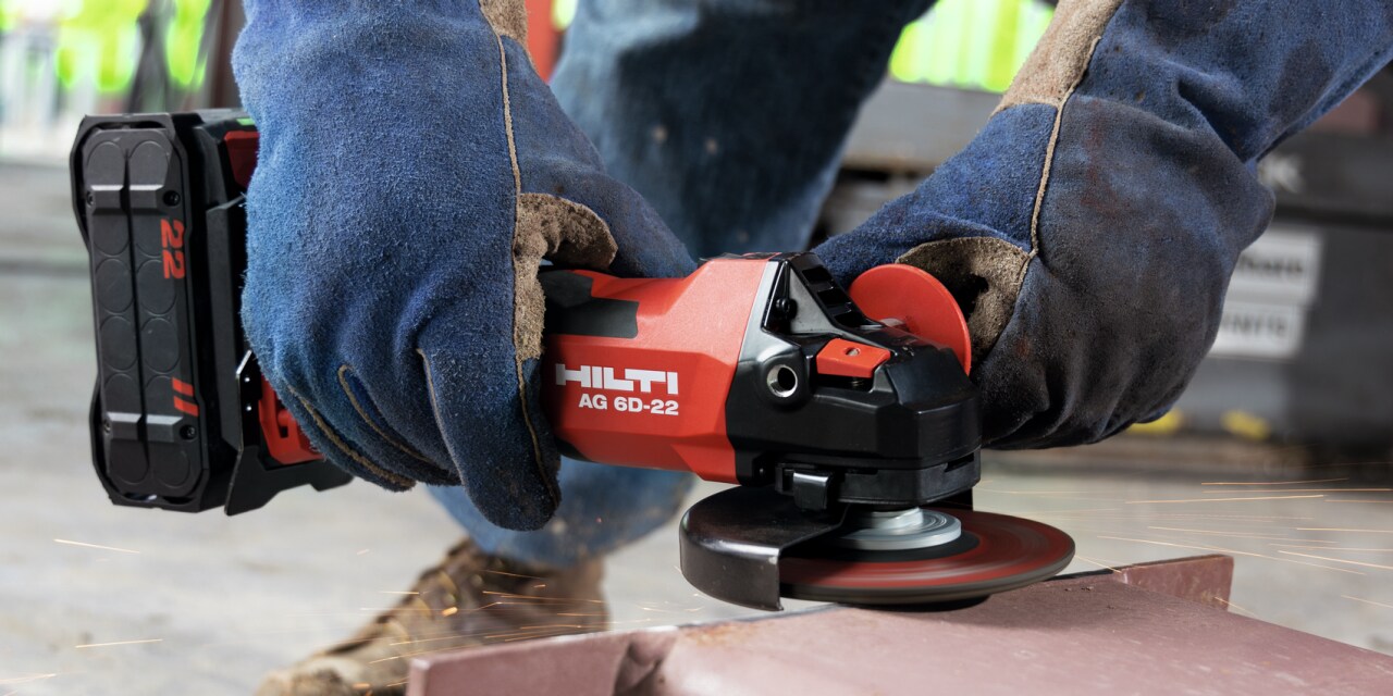 A man using cordless Red Hilti Angle Grinder.