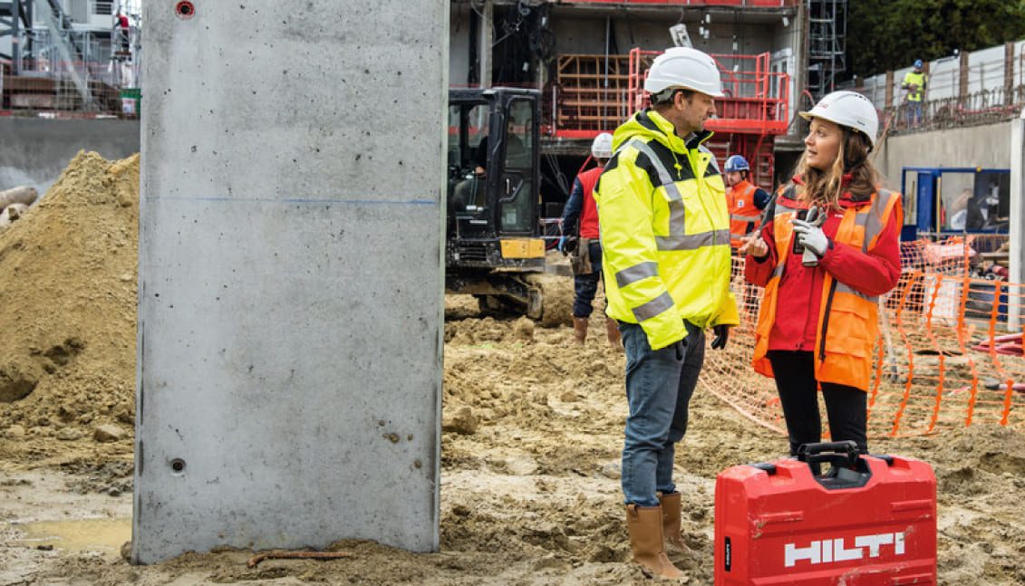 Chargé d'affaires Hilti conseillant un client sur un chantier