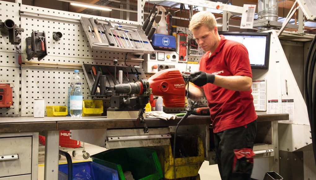 Un agent Hilti répare un burineur dans un centre de réparation pour outils