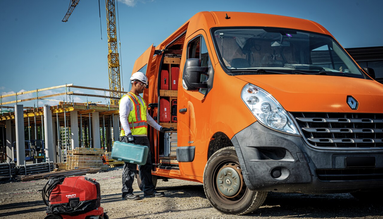 Un trabajador en una obra, junto a su furgoneta