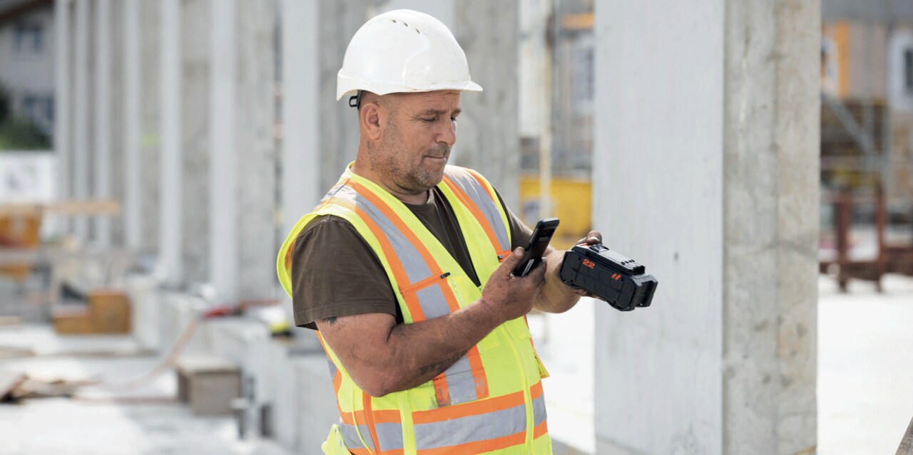 Un ouvrier sur chantier scanne une batterie Nuron