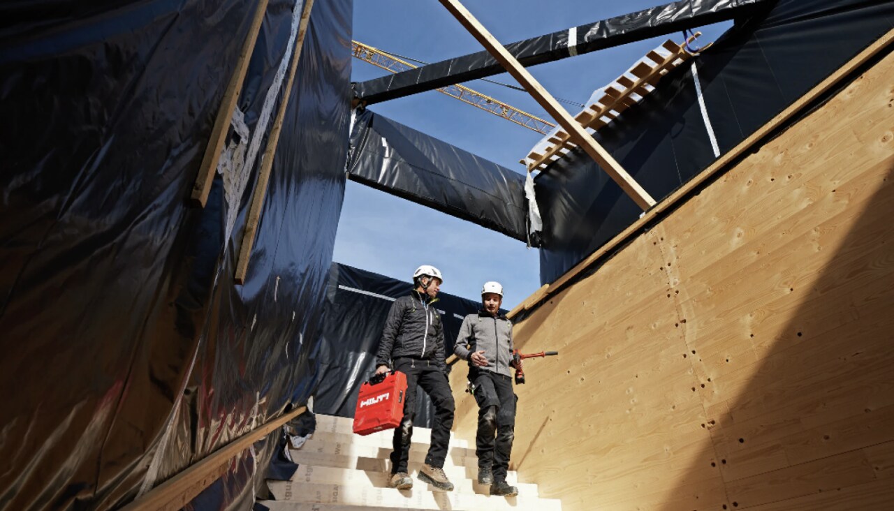 Deux ouvriers descendent des escaliers sur un chantier