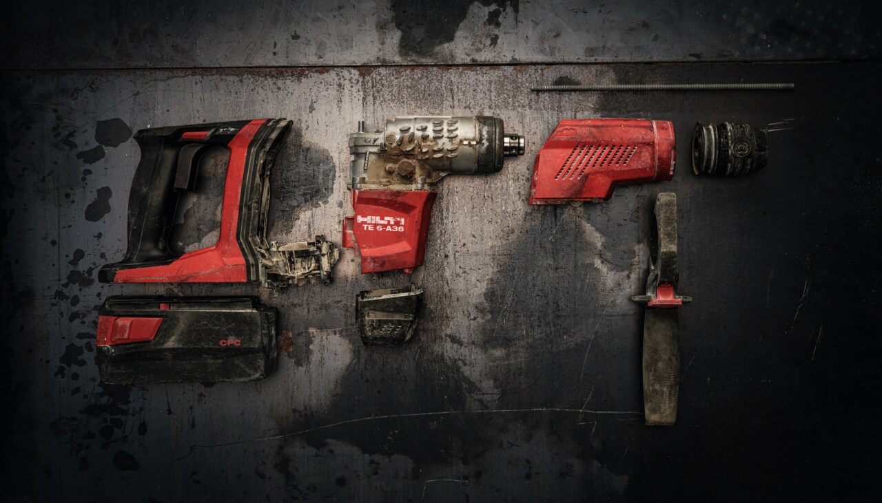 Um martelo rotativo Hilti desmontado em 3 peças