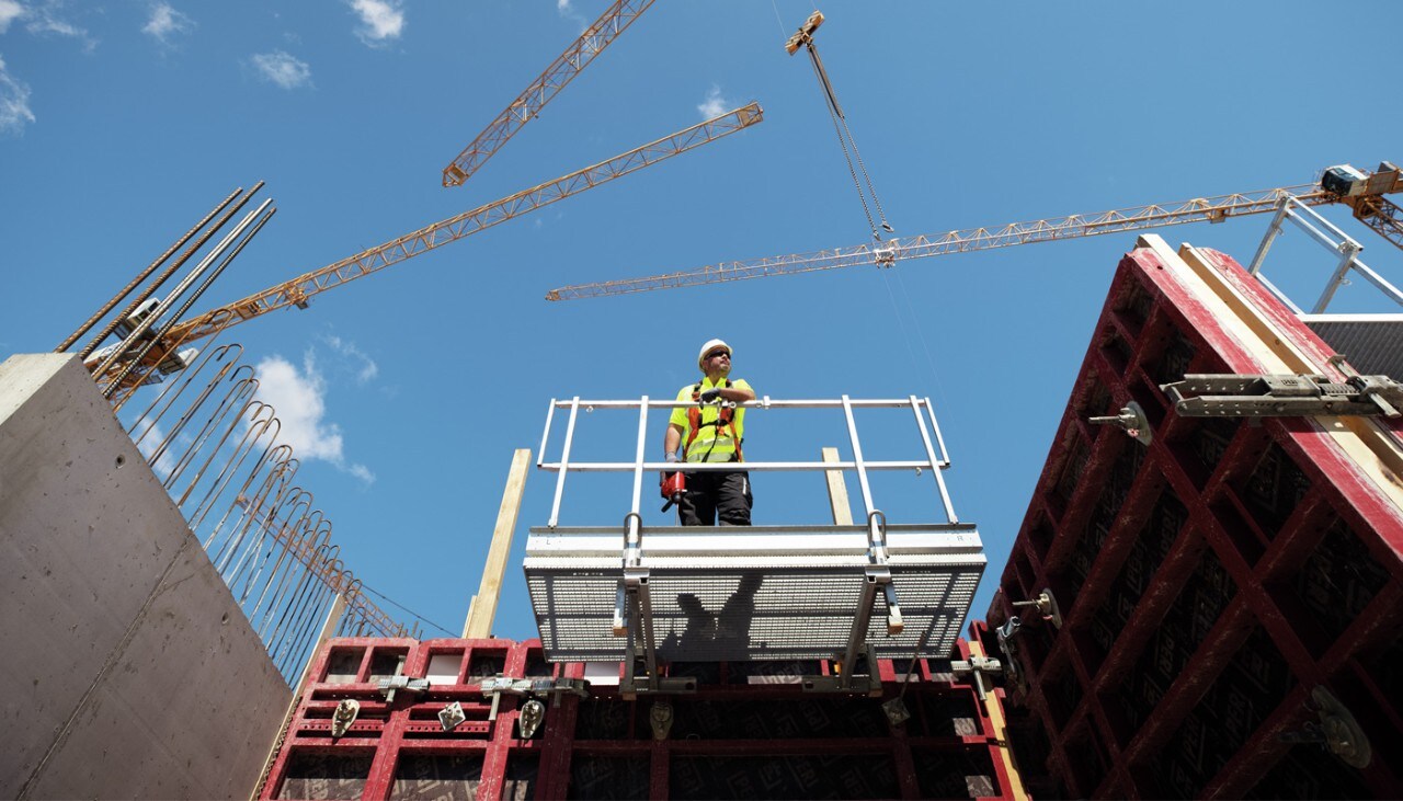 Pracownik na rusztowaniu na placu budowy