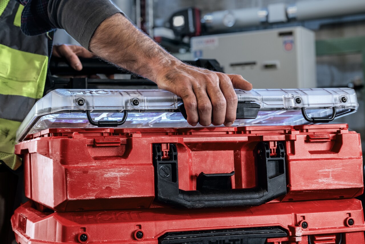 Hand opening the consumables compartment of the Prokit