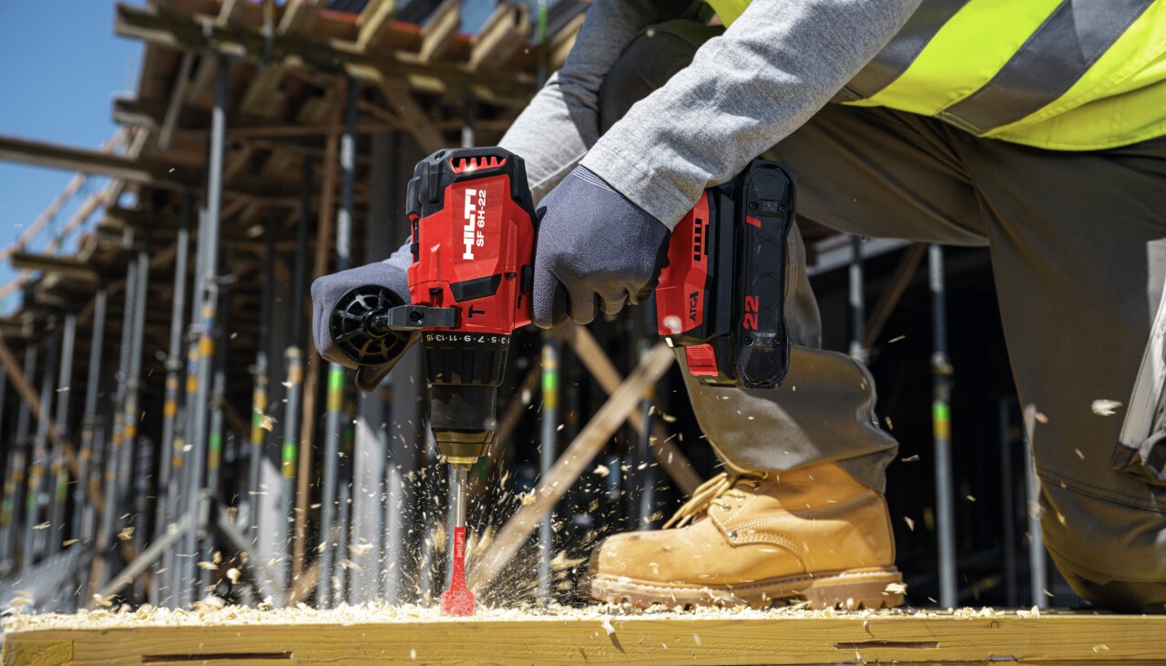 Muncitor care folosește a treia generație de șurubelnițe cu percuție mecanică pe acumulator Nuron SF 6H-22, cu baterie B22-85 și burghiu spadă în lemn