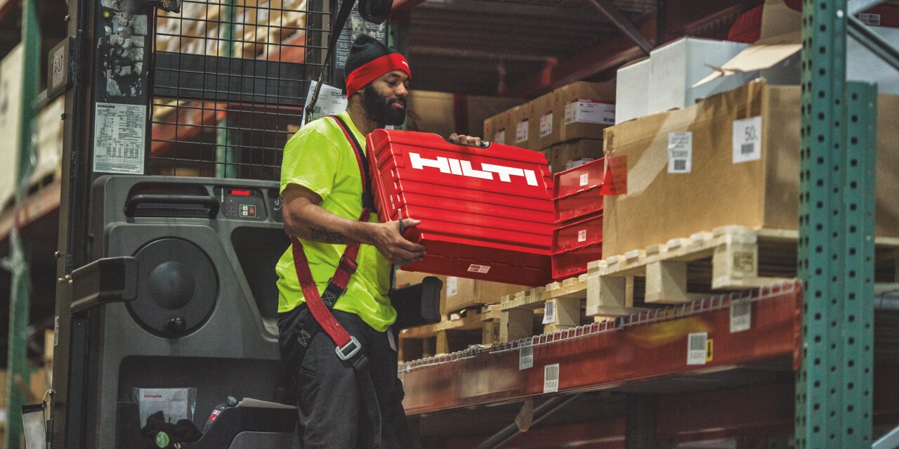 Skladník ukládá kufr do regálu