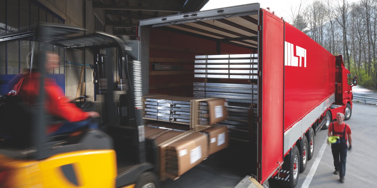 Ještěrka nakládá nosníky do kamionu