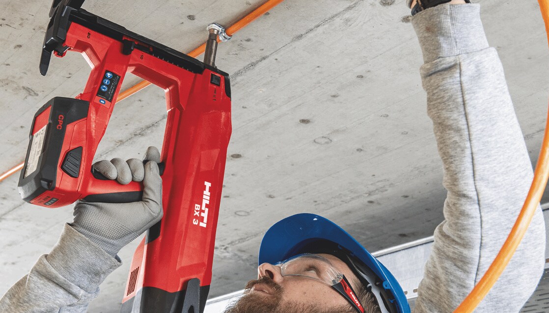 Hilti darbuotojas naudoja BX 3 įrankį, kad pritvirtinti elektros laidus prie lubų