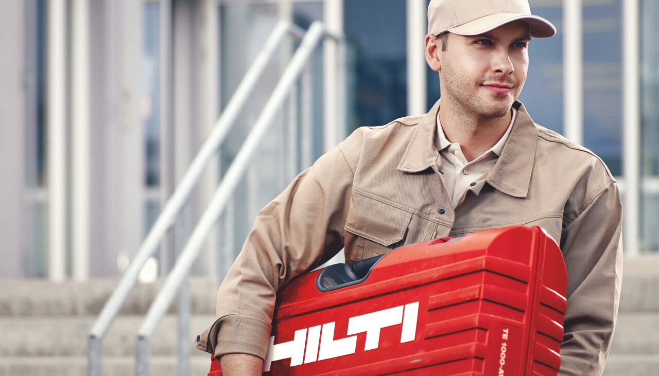 Hilti darbuotojas nešantis hilti lagaminą