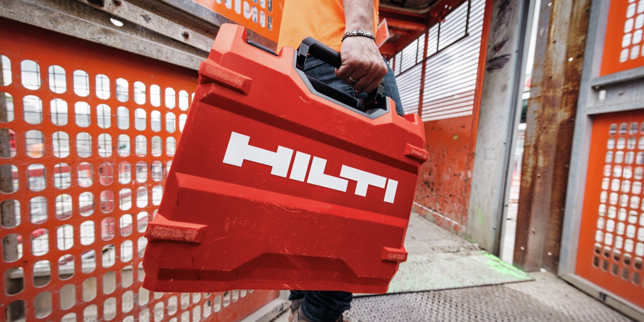 Hilti darbuotojas nešantis hilti lagaminą