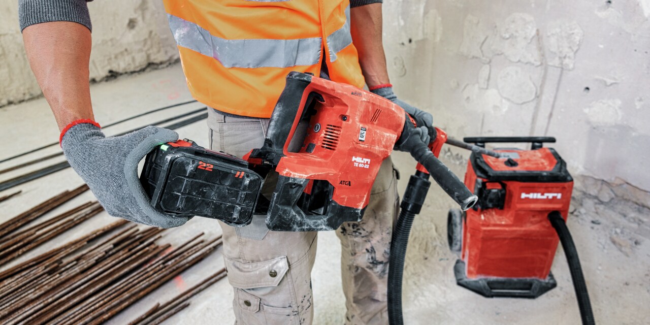 Būvdarbinieks, kas izmanto hilti rīku