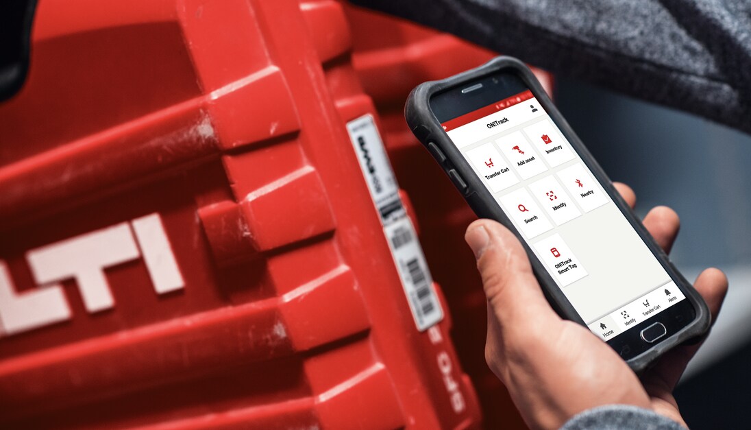 A worker uses ON!Track on a mobile device to scan a Hilti tool box
